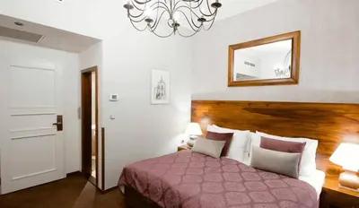 a bedroom with a bed and a mirror and a chandelier at Hotel Residence Agnes in Prague