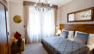 a bedroom with a bed and a mirror and a chandelier at Hotel Residence Agnes in Prague