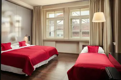 a hotel room with two beds with red covers at Perla Hotel in Prague