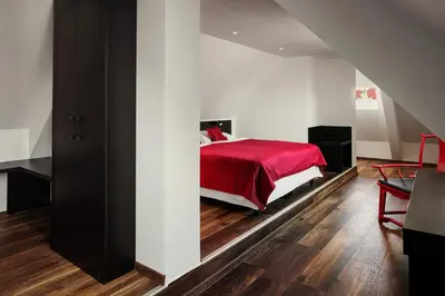 a bedroom with a bed with a red blanket at Perla Hotel in Prague