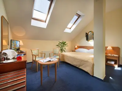 a bedroom with a bed and a table and chairs at EA Hotel Tosca in Prague