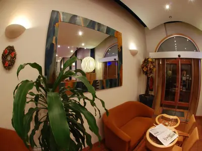 a living room with a plant and a mirror at EA Hotel Tosca in Prague