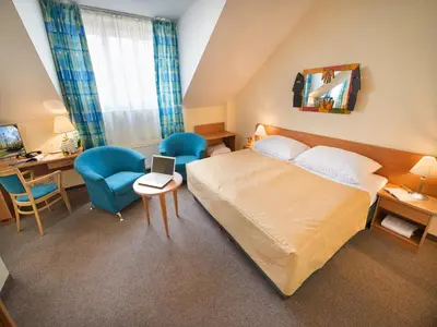 a hotel room with a bed and a desk and chairs at EA Hotel Tosca in Prague