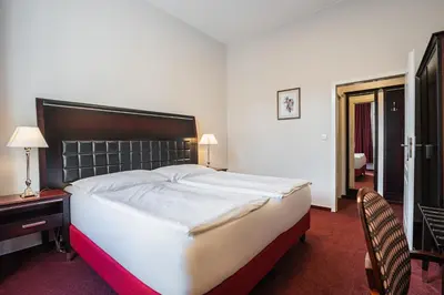 a bedroom with a large bed and a desk and chair at EA Hotel Tosca in Prague