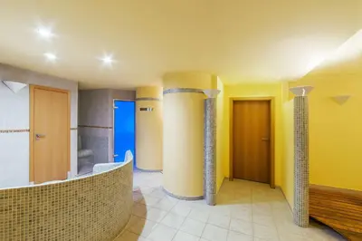 a bathroom with yellow walls and columns in a room at NH Prague City in Prague