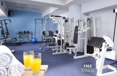 a gym with two glasses of orange juice and machines at COLORFACTORY SPA Hotel - Czech Leading Hotels in Prague