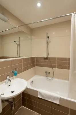 a bathroom with a tub and a sink and a shower at Aparthotel Angel in Prague