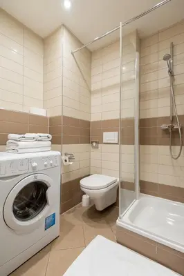 a bathroom with a washing machine and a toilet at Aparthotel Angel in Prague