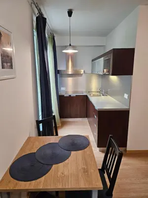a kitchen with a wooden table and a dining room at Aparthotel Angel in Prague