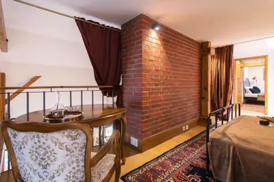 a room with a brick wall and a table and a bed at Billionaires Club LOFT Sauna City Center in Prague
