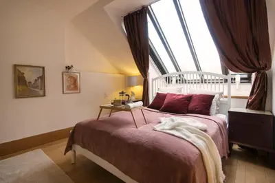 a bedroom with a bed with a large window at Billionaires Club LOFT Sauna City Center in Prague