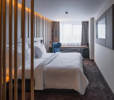 a hotel room with a bed and a chair at OREA Hotel Pyramida Praha in Prague