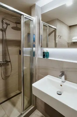 a bathroom with a sink and a shower at OREA Hotel Pyramida Praha in Prague