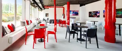 a room with red chairs and tables and windows at OREA Hotel Pyramida Praha in Prague