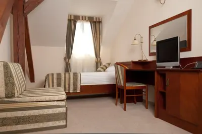 a bedroom with a bed and a desk with a computer at Amigo City Centre in Prague