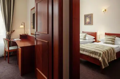 a hotel room with a bed and a desk and a bedroom at Amigo City Centre in Prague