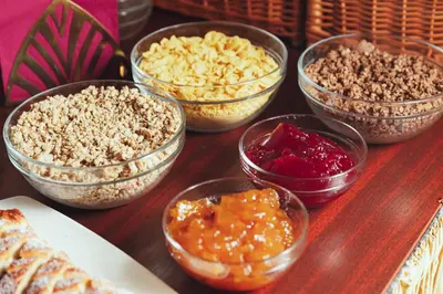 a wooden table topped with bowls of different types of food at Amigo City Centre in Prague