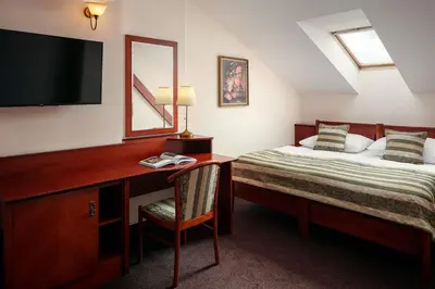 a bedroom with a bed and a desk with a television at Amigo City Centre in Prague