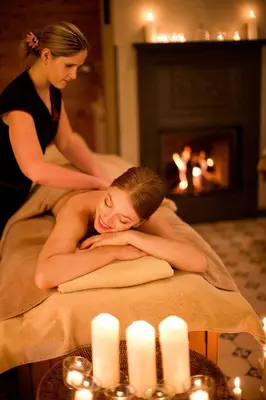 a woman laying on a bed in a room with candles at Chateau Mcely in Mcely