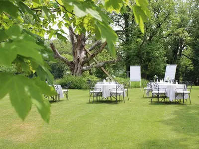a group of tables and chairs on the grass at Chateau Mcely in Mcely