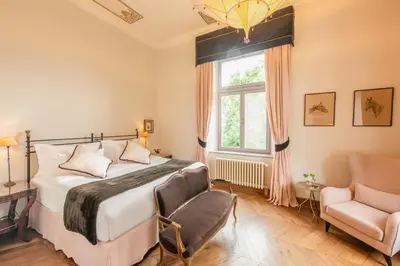 a bedroom with a bed and a chair and a window at Chateau Mcely in Mcely