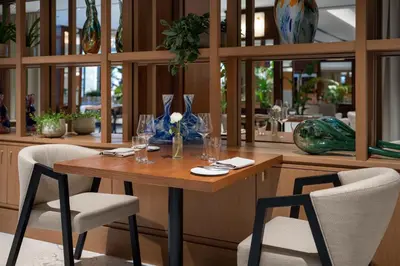 a table with glasses and two chairs in a restaurant at Almanac X Alcron Prague in Prague