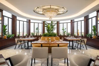 a restaurant with tables and chairs and a chandelier at Almanac X Alcron Prague in Prague