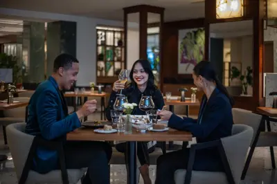 a group of people sitting around a table in a restaurant at Almanac X Alcron Prague in Prague