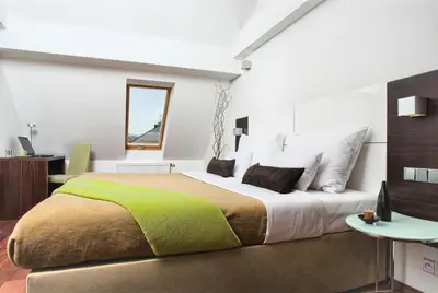 a bedroom with a large bed and a table at Residence Karolina in Prague