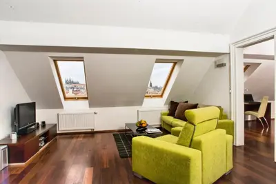 a living room with a yellow couch and a tv at Residence Karolina in Prague