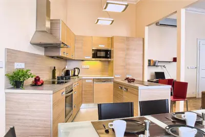 a large kitchen with wooden cabinets and a table at Residence Karolina in Prague