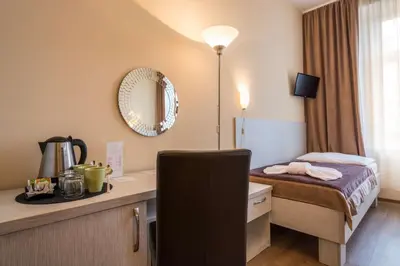 a hotel room with a bed and a desk with a mirror at Prague Centre Plaza in Prague