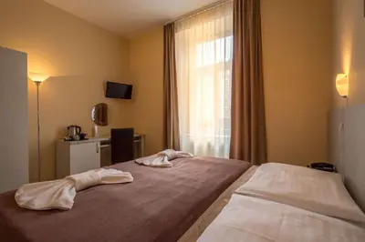 a bedroom with two towels on a bed with a window at Prague Centre Plaza in Prague