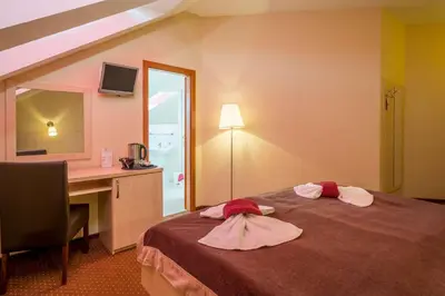 a hotel room with a bed with a desk and a mirror at Prague Centre Plaza in Prague
