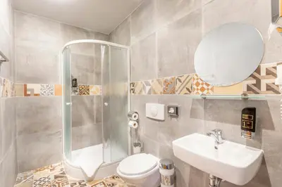 a bathroom with a toilet and a sink and a mirror at Prague Centre Plaza in Prague