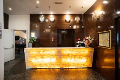 a lobby with a reception desk and clocks on the wall at Hotel Assenzio Prague in Prague