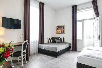 a bedroom with a bed and a table with a chair at Hotel Assenzio Prague in Prague