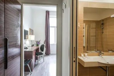 a bathroom with a sink and a desk at Hotel Assenzio Prague in Prague