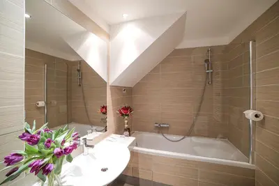 a bathroom with a tub and a sink and a bath tub at Hotel Assenzio Prague in Prague