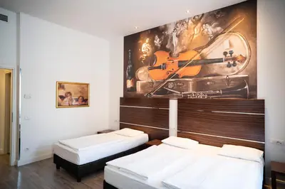 a room with two beds and a mural of a violin at Hotel Assenzio Prague in Prague