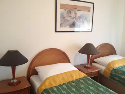 two beds in a room with two lamps on tables at Hotel CHOTOL in Horoměřice