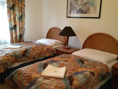 a hotel room with two beds and a lamp at Hotel CHOTOL in Horoměřice