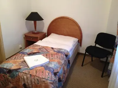 a hotel room with a bed and a chair at Hotel CHOTOL in Horoměřice