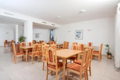 a dining room with wooden tables and chairs at Hotel CHOTOL in Horoměřice