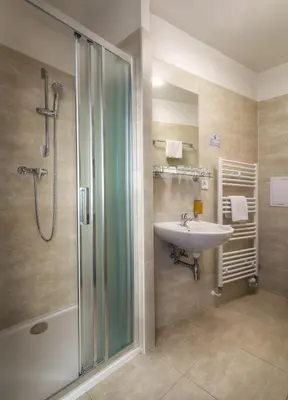 a bathroom with a sink and a shower at Hotel Harmony in Prague