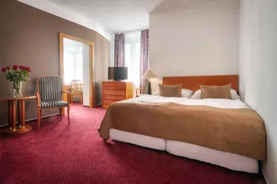 a hotel room with a bed and a chair at Hotel Harmony in Prague