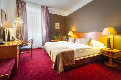 a hotel room with a large bed and a desk at Hotel Harmony in Prague