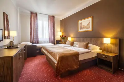 a hotel room with a large bed and a desk at Hotel Harmony in Prague