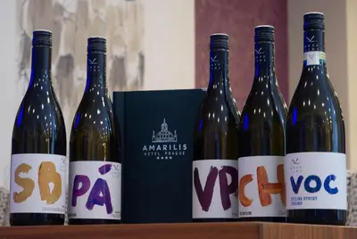 a group of four bottles of wine sitting on a shelf at Amarilis in Prague