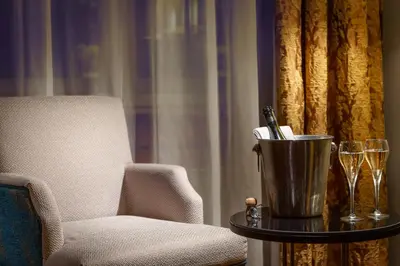 a living room with a chair and a table with a bucket at Art Deco Imperial Hotel in Prague
